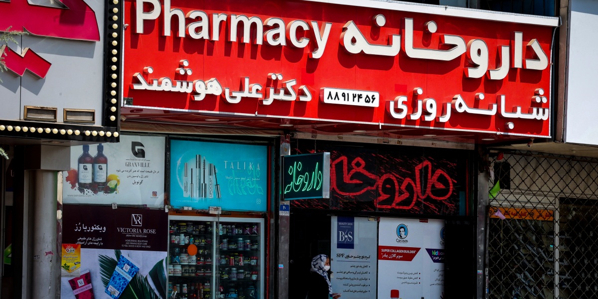 An Iranian woman leaves a pharmacy next to shuttered shops at Valiasr square in the capital Tehran leading to the country's north, on August 16, 2021, at the start of renewed restrictions for 5 days to mitigate the spread of the covid pandemic. - Iran a day earlier reported over 600 daily Covid deaths for the first time, ahead of tightened curbs to contain the spread of the virus, leading the authorities to mandate government offices, banks and non-essential businesses to close countrywide from August 16 through 21, and impose a ban on car travel between provinces due to run until August 27. (Photo by ATTA KENARE / AFP) (Photo by ATTA KENARE/AFP via Getty Images)