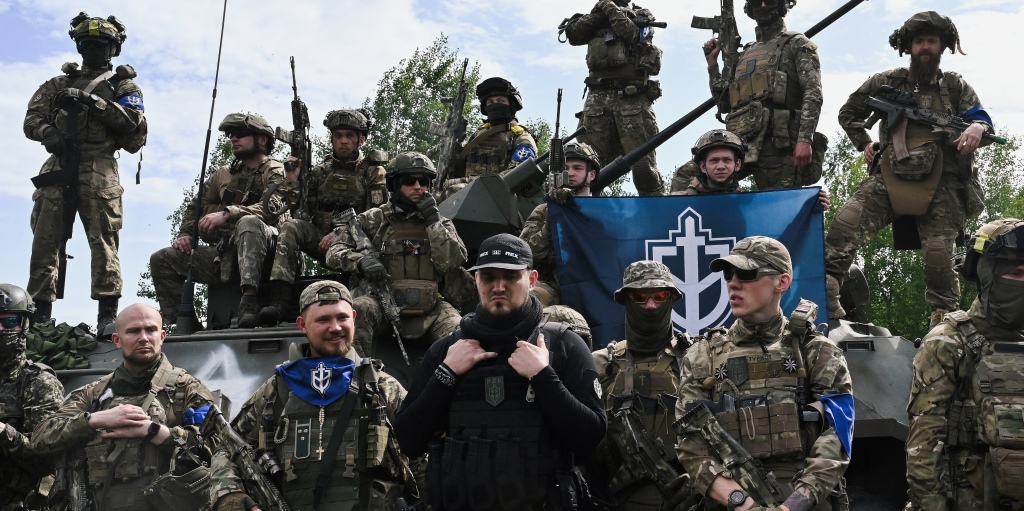 TOPSHOT - The founder of the Russian Volunteer Corps, Denis (C), known as "White Rex", flanked  by fighters in camouflage attend a presentation for the media in northern Ukraine, not far from the Russian border, on May 24, 2023, amid Russian military invasion on Ukraine. Russian nationals fighting on Ukraine's side on May 24 hailed as a "success" a brazen mission to send groups of volunteers across the border into southern Russia and back. Russia on May 23 said it deployed jets and artillery to fight off armed attackers who crossed into the southern region of Belgorod from Ukraine, exposing weaknesses on Moscow's frontier. (Photo by SERGEY BOBOK / AFP) (Photo by SERGEY BOBOK/AFP via Getty Images)